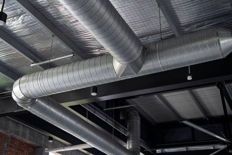 LEV testing. Close-up view of a metallic air duct ventilation system installed along the ceiling of a modern industrial-style building.